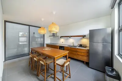 a kitchen with a wooden table and a refrigerator at Casa Nadi in Seminyak