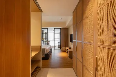 a hotel room with a bed and a closet at de' Asasta Apartment Benoa N-511 in Nusa Dua