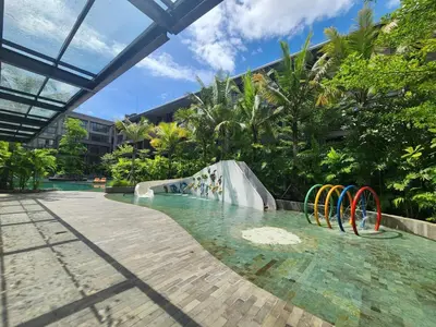 a pool with a water slide in a resort at de Asasta Apartment Benoa E-105 in Nusa Dua