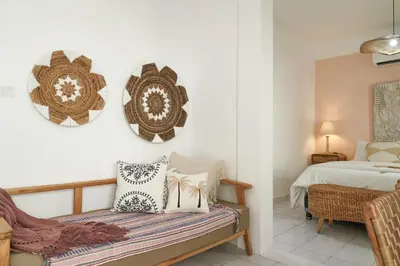a bedroom with a bed and a bench with pillows at Motel Molly Boutique Rooms Seminyak in Seminyak