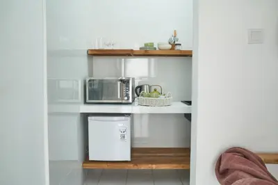 a kitchen with a trash can and a microwave at Motel Molly Boutique Rooms Seminyak in Seminyak