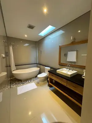 a bathroom with a tub and a toilet and a sink at Villa Lil'u in Seminyak
