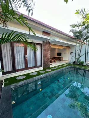 a swimming pool in front of a house at Villa Lil'u in Seminyak