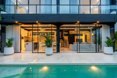 a glass house with a pool in front of it at Villa Vantage 8, Umalas in Kerobokan