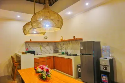 a kitchen with a table and a refrigerator at Villa Sinergi Seminyak 3 in Seminyak