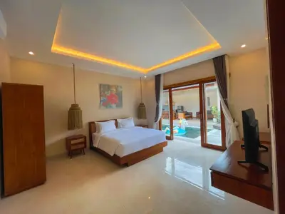 a bedroom with a bed and a tv in it at Villa Sinergi Seminyak 3 in Seminyak
