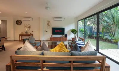 a living room with a couch with pillows at Villa Cora Seminyak Walk to Double Six Beach in Seminyak