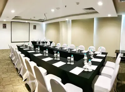 a conference room with a long table and white chairs at d'primahotel Petitenget Seminyak 2 in Seminyak