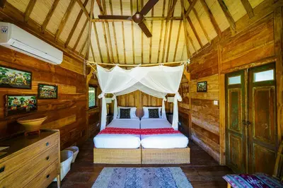 a bedroom with a bed in a wooden cabin at Abaca Villas in Seminyak