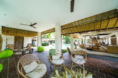 an open living room with chairs and a patio at Abaca Villas in Seminyak