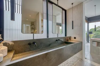 a bathroom with a large sink and mirrors at Luxury Industrial-Style 2BR Villa Kirma Near the Beach in Canggu