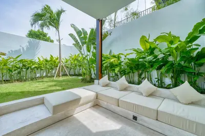 a white couch in a room with plants at Luxury Industrial-Style 2BR Villa Kirma Near the Beach in Canggu