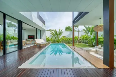 an indoor swimming pool in a house with a living room at Luxury Industrial-Style 2BR Villa Kirma Near the Beach in Canggu