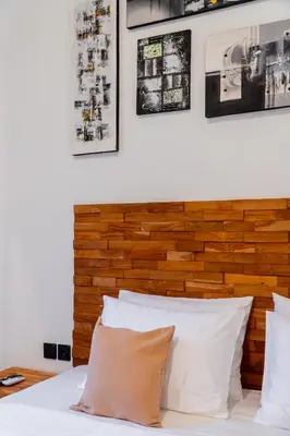 a bed with white pillows and pictures on the wall at Danbi Villa Bali By Bali Cabin in Canggu
