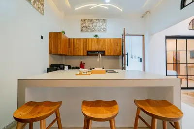 a kitchen with a counter and two stools at Danbi Villa Bali By Bali Cabin in Canggu