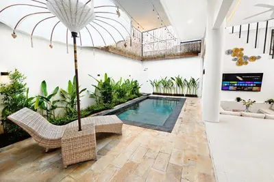 a pool in a room with a chair and a table at Danbi Villa Bali By Bali Cabin in Canggu