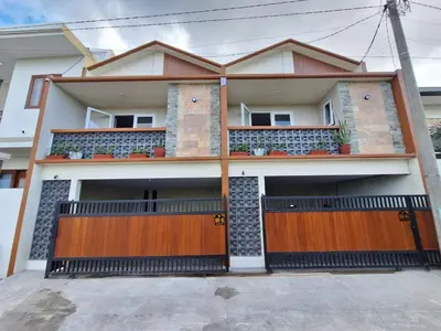 a house with two garage doors in front of it at Home88 Sanur in Sanur