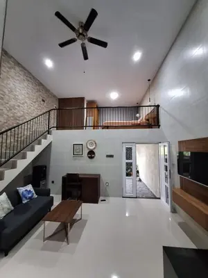 a living room with a couch and a ceiling fan at Home88 Sanur in Sanur