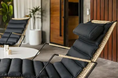 a room with two black chairs and a table at Brand New 4BR Villa with Pool, Sauna & Fire pit close to Nusa Dua and Uluwatu in Jimbaran