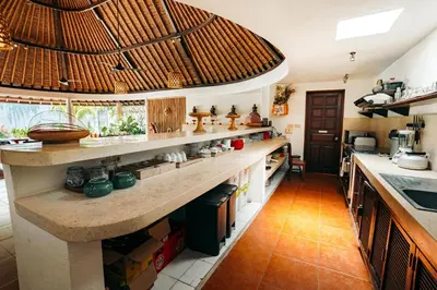 a kitchen with a large counter with a large ceiling at Bali Akasa Villa in Seminyak