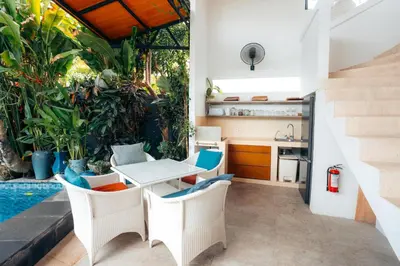 an outdoor kitchen and dining area with a table and chairs at Bali Akasa Villa in Seminyak