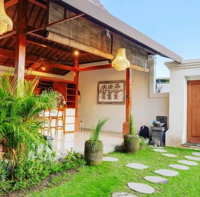 a patio of a house with a roof at Sari alam guest house in Kerobokan