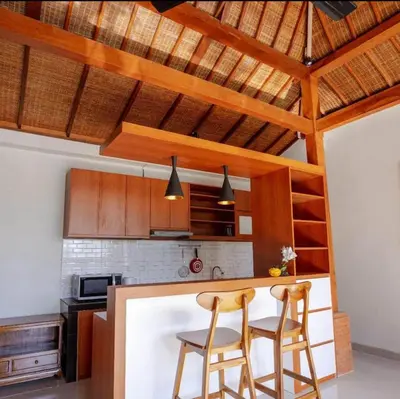 a kitchen with two chairs and a table in a kitchen at Sari alam guest house in Kerobokan
