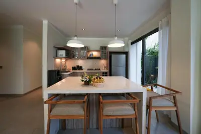 a kitchen with a large table with chairs and a tableasteryasteryasteryasteryastery at Twin Villas Drupadi 8BR Seminyak by Exotic Bali Properties in Seminyak