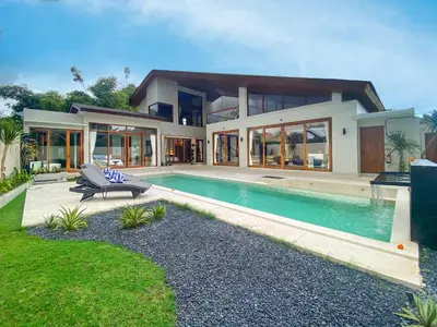 a house with a swimming pool in front of it at The Aurum Canggu Villas by Nagisa Bali in Canggu