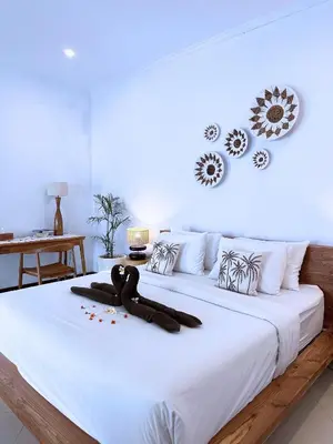 a white bed with a teddy bear laying on it at A strategic 2 bedroom villa in seminyak in Seminyak