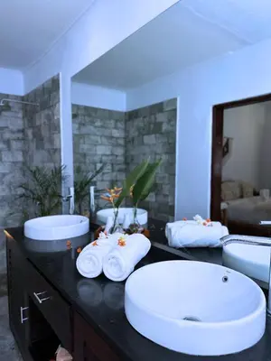 a bathroom with two sinks and two mirrors at A strategic 2 bedroom villa in seminyak in Seminyak
