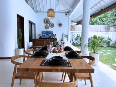 a dining room with a wooden table and chairs at A strategic 2 bedroom villa in seminyak in Seminyak