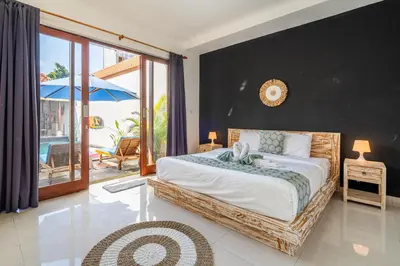 a bedroom with a large bed and a balcony at Villa Azure 3 - Tropical 4-Bedroom Pool Villa Near Seminyak in Seminyak
