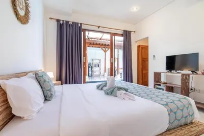 a large white bed in a room with a television at Villa Azure 3 - Tropical 4-Bedroom Pool Villa Near Seminyak in Seminyak