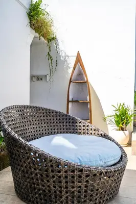 a wicker chair sitting on a patio at Villa Azure 2 - Master Suite in shared Pool Villa in Seminyak