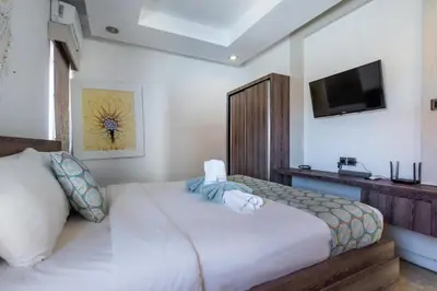 a bedroom with a bed and a tv on the wall at Villa Azure 2 - Master Suite in shared Pool Villa in Seminyak