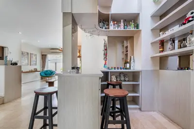 a kitchen with two stools at a bar at Villa Azure 2 - Master Suite in shared Pool Villa in Seminyak