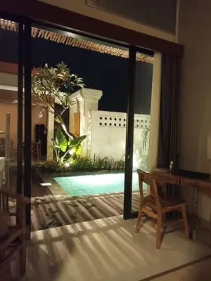 a living room with a view of a swimming pool at Villa Juanjo Sanur in Sanur