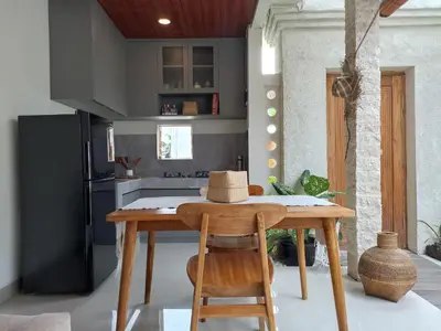 a kitchen with a wooden table with a hat on it at Villa Juanjo Sanur in Sanur