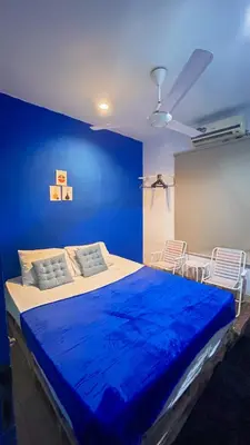 a blue bedroom with a large bed with a blue wall at Santorini House in Bali Near Airport in Kuta