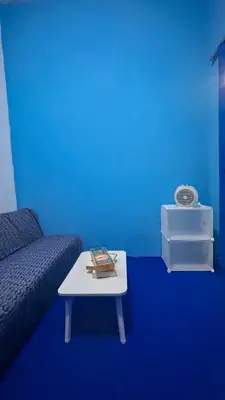 a blue room with a couch and a coffee table at Santorini House in Bali Near Airport in Kuta