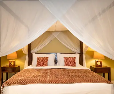 a bedroom with a bed with a canopy at The Clovewood Villa in Seminyak