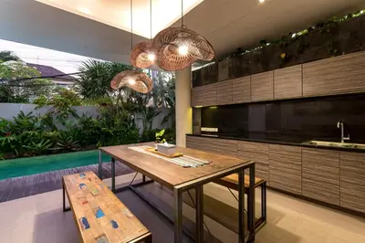 a kitchen with a wooden table and a pool at Swan Villa R in Seminyak