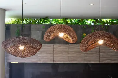 three wicker pendant lights hanging over a table at Swan Villa R in Seminyak