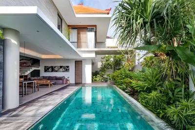 an external view of a house with a swimming pool at Swan Villa R in Seminyak