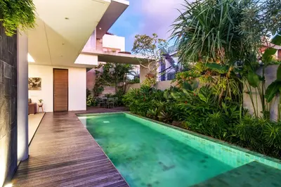 a swimming pool in the backyard of a house at Swan Villa R in Seminyak