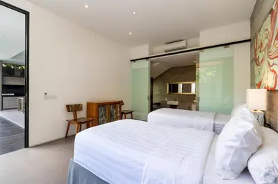 a bedroom with a white bed and a large mirror at Swan Villa R in Seminyak