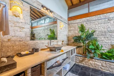a bathroom with a sink and a stone wall at Tropical Villas - 2 Bed & 3 Bed in Kerobokan
