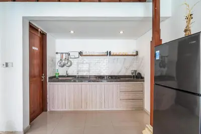 a kitchen with a sink and a refrigerator at Villa Azure 3 - Private Suite in Shared Tropical Pool Villa in Seminyak
