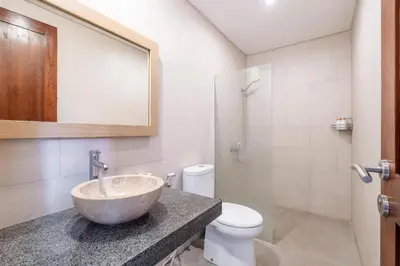 a bathroom with a sink and a toilet at Villa Azure 3 - Private Suite in Shared Tropical Pool Villa in Seminyak